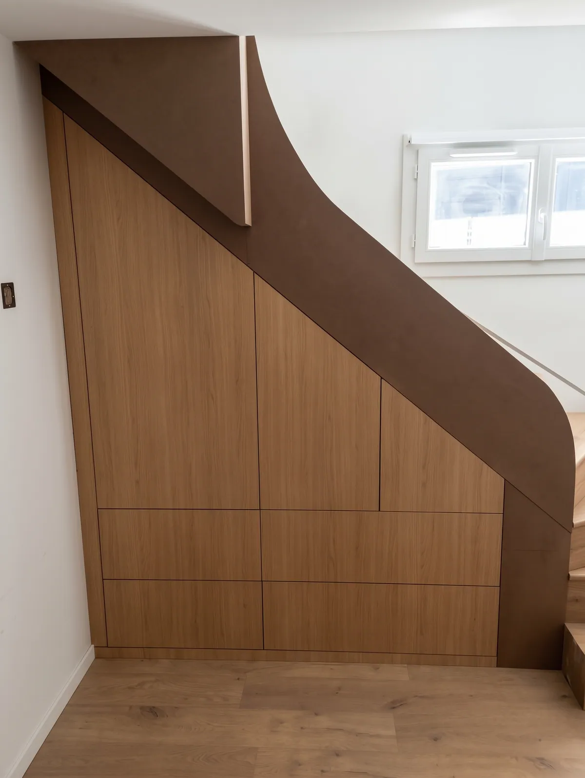 Après : placard intégré sous le même escalier, façades en bois