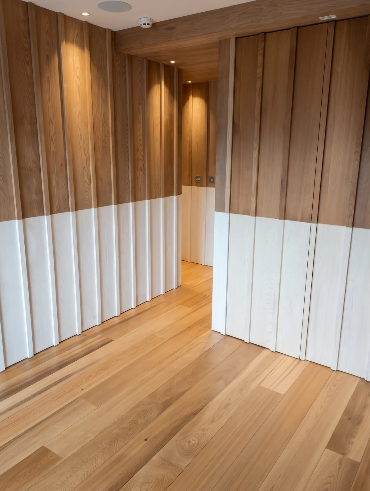 Habillage mural en bois avec portes intégrées, dans un couloir