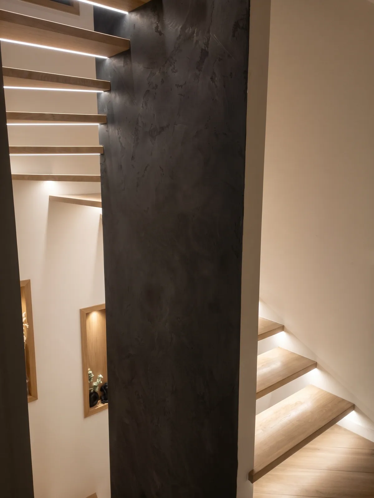 Escalier à marches en bois éclairées, vu depuis l'étage