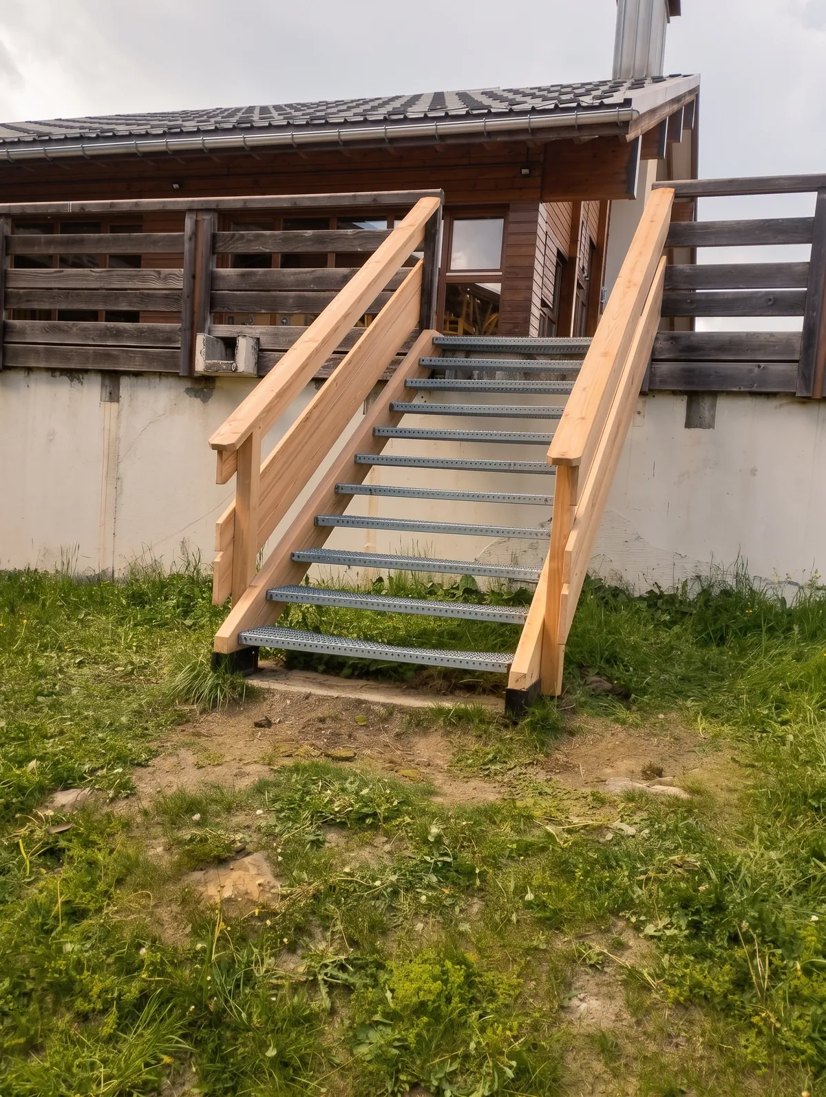 Escalier extérieur avec garde-corps en bois, menant à une terrasse